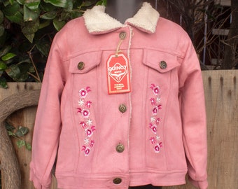 May include: Pink denim jacket with a faux fur collar and floral embroidery. The jacket has a button closure and a tag that reads "Quincy Boots, The Real American Boot".
