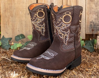 May include: Brown leather children's cowboy boots with a side zipper and embroidered floral designs in gold and silver thread.
