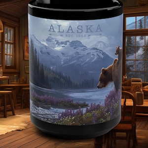 May include: Black ceramic mug with a scenic image of a lake, mountains, and two brown bears. The text "ALASKA EST. 1959" is printed on the mug.