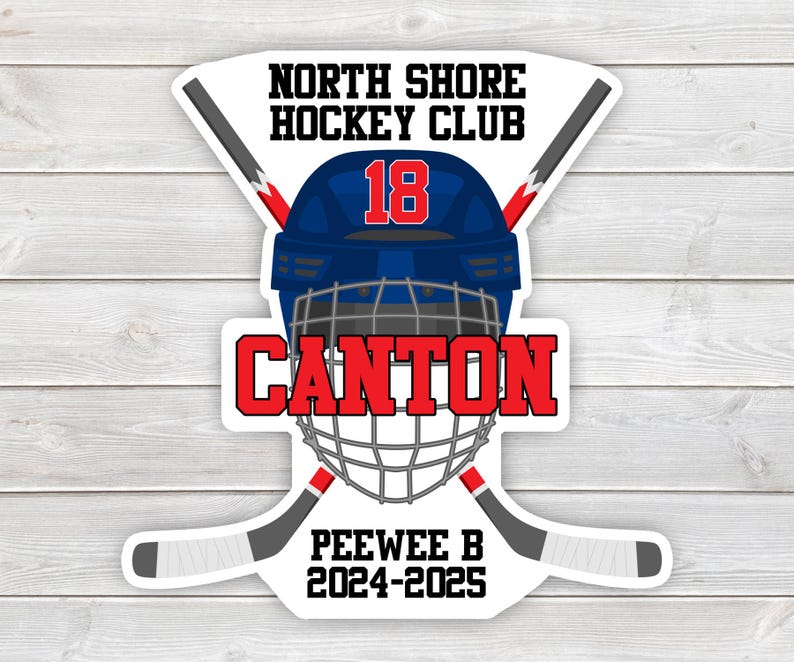 May include: A white sticker with a blue and red hockey helmet with the number 18 on it. The text "North Shore Hockey Club" is above the helmet and the text "Canton" is below the helmet. The text "Peewee B 2024-2025" is at the bottom of the sticker.