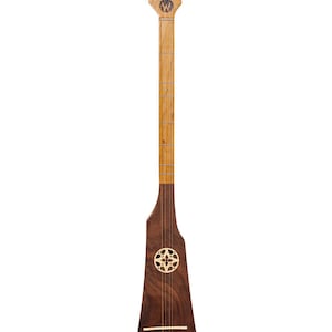 May include: A wooden guitar with a walnut body and a maple neck. The guitar has a unique shape with a rounded headstock and a pointed body. The guitar has a rosette with a Celtic knot design.