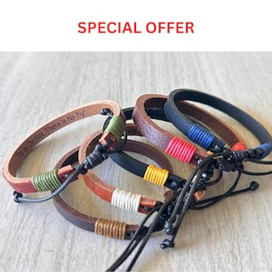May include: A collection of leather bracelets featuring adjustable black cord closures and colorful thread accents. One bracelet is engraved with the text Do or Do Not, There Is No Try. The bands are brown and black with green, red, blue, yellow, white, and tan thread.