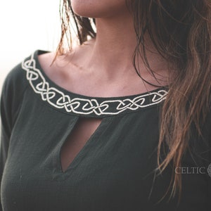 Close up of Celtic knot embroidery on the neckline of a green Celtic dress, showing the detail of this breathable long sleeve folklore dress.