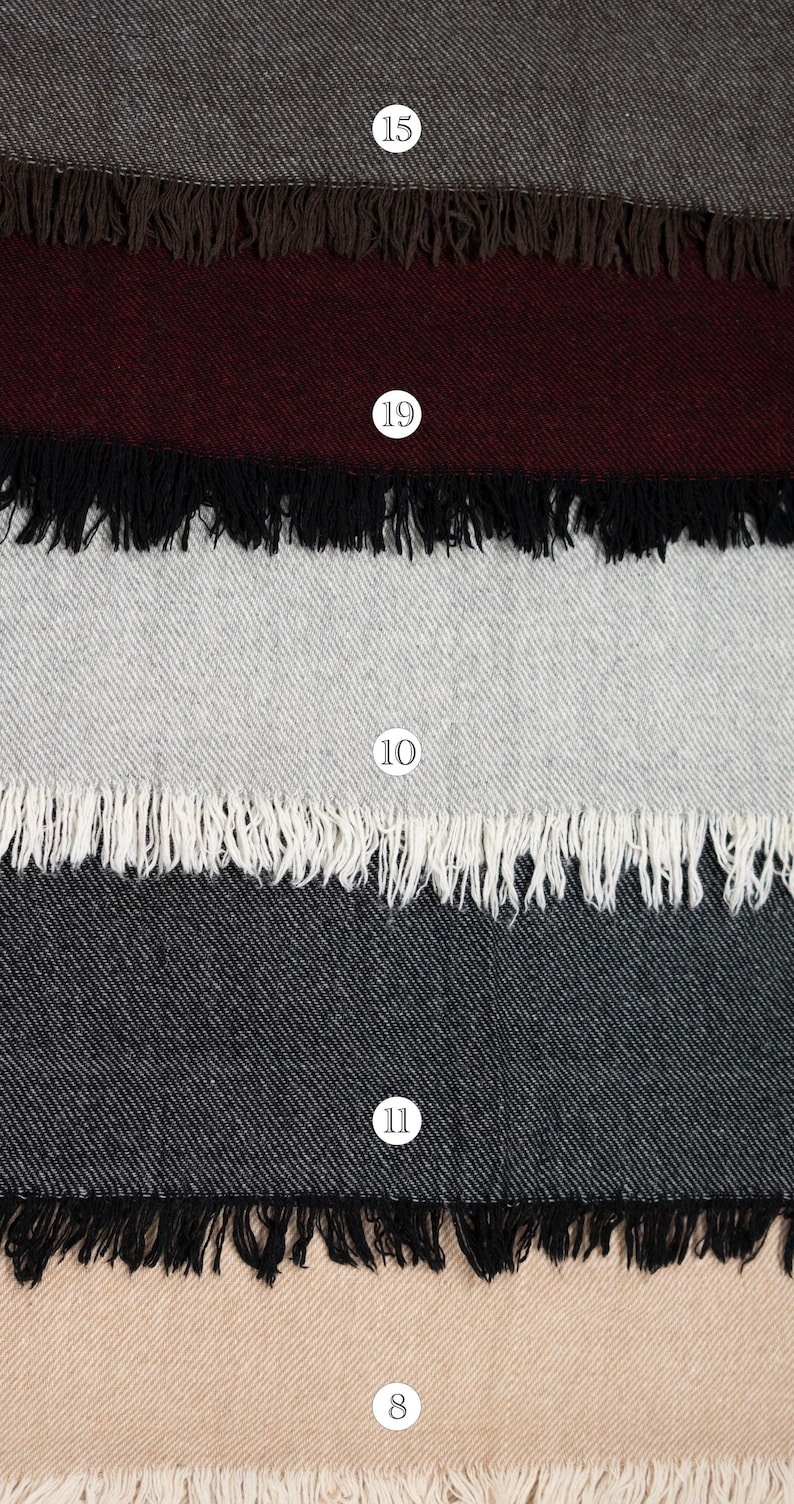 Pu&ograve; includere: Una collezione di cinque campioni di tessuto rettangolari disposti verticalmente, ognuno caratterizzato da un colore solido distinto, una trama diagonale e un bordo sfrangiato. I colori includono grigio scuro, bordeaux intenso, grigio chiaro, antracite e beige.