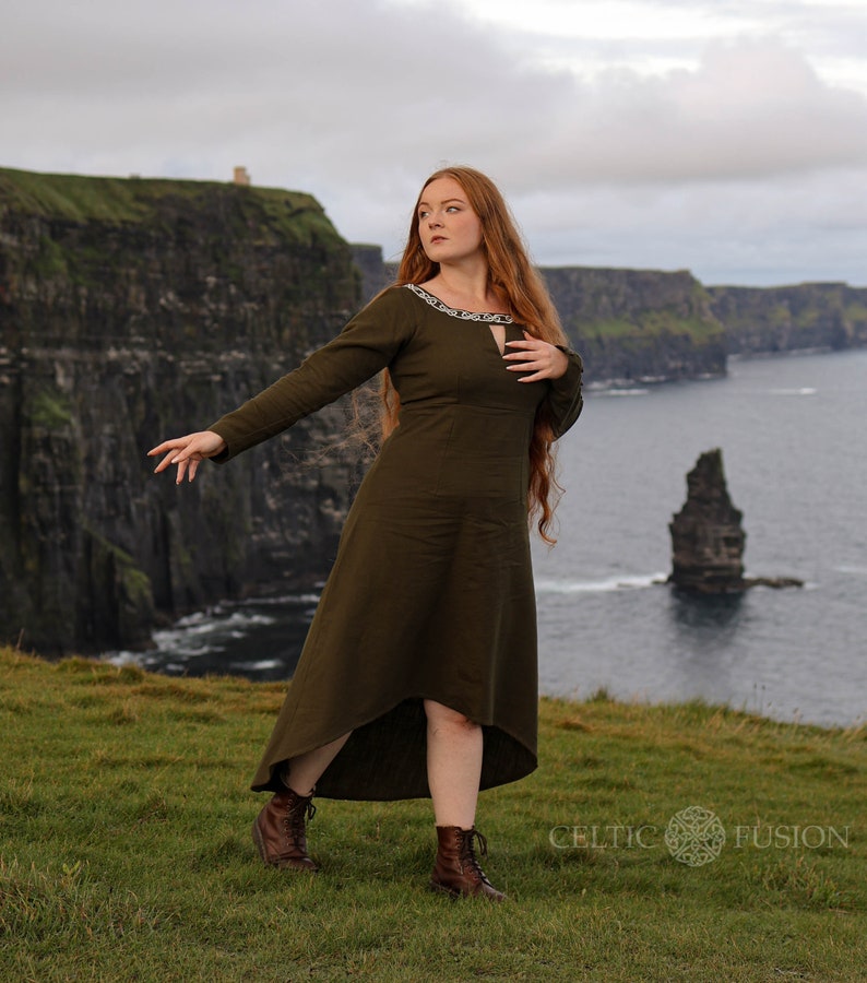 Mystical green Celtic dress with intricate Celtic embroidery, featuring a high-low skirt, buttoned sleeves, and a medieval-inspired design. A perfect choice for historical and bohemian fashion lovers.