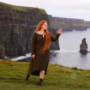 Mystical green Celtic dress with intricate Celtic embroidery, featuring a high-low skirt, buttoned sleeves, and a medieval-inspired design. A perfect choice for historical and bohemian fashion lovers.
