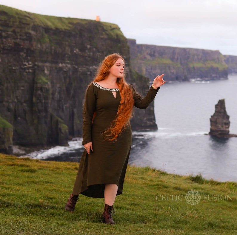 Mystical green Celtic dress with intricate Celtic embroidery, featuring a high-low skirt, buttoned sleeves, and a medieval-inspired design. A perfect choice for historical and bohemian fashion lovers.