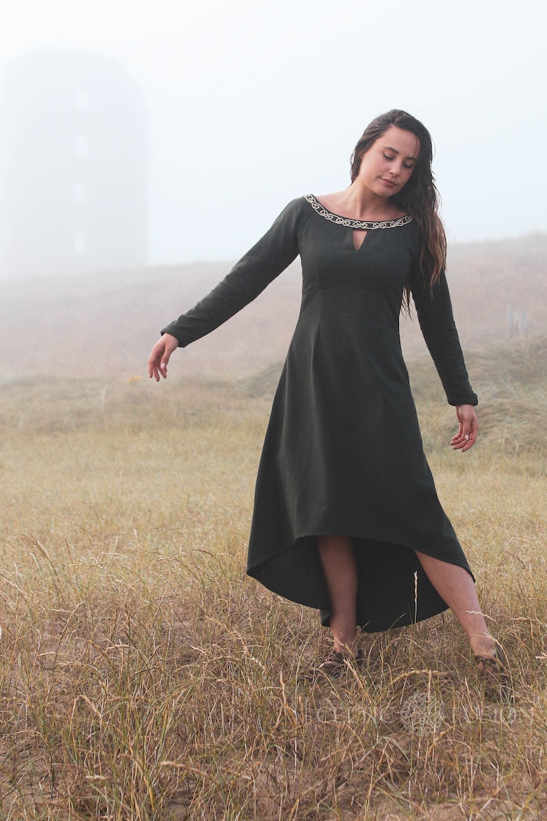 Green Celtic dress in soft natural quality heavy cotton, styled as a breathable long sleeve folklore dress with an elegant high low skirt in a misty meadow.
