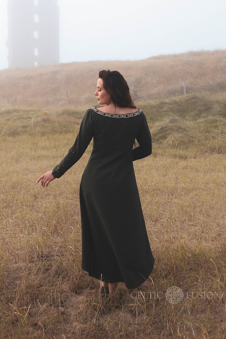 Back view of green Celtic dress with long sleeves and flowing silhouette, an alternative wedding guest dress with high low skirt and folklore styling.