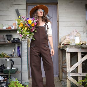 Discover our Meadow Brown Dungarees, an earthy brown jumpsuit trimmed with oak tweed, designed for folklore-inspired style, comfort, and everyday wear.
