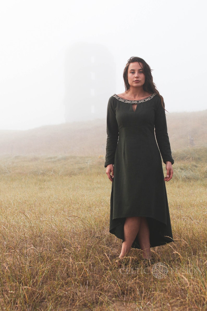 Mystical green Celtic dress with intricate Celtic embroidery, featuring a high-low skirt, buttoned sleeves, and a medieval-inspired design. A perfect choice for historical and bohemian fashion lovers.