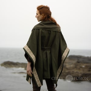 May include: A dark green hooded cloak with a brown and cream trim. The cloak has a belt and is worn by a person with red hair.