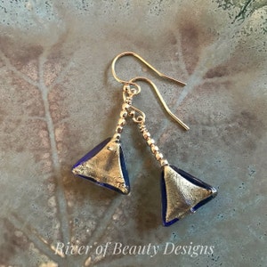 May include: Gold and blue glass triangle earrings with gold beads and a gold wire hook.
