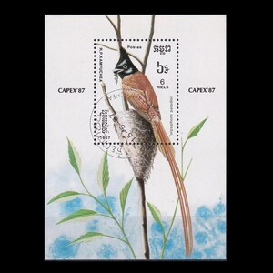 May include: A vintage postage stamp from Cambodia featuring a colorful bird with a long tail, perched on a branch. The stamp is dated 1987 and reads "CAPEX '87" and "6 RIELS".