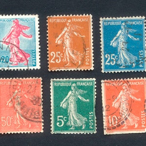 以下が含まれることがあります： トーチを持った流れるようなローブを着た女性を描いた、フランスのヴィンテージ切手6枚。切手は5c、10c、25c、50cの額面です。切手は青、緑、オレンジ、赤など、さまざまな色があります。
