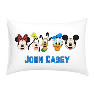May include: White pillowcase featuring cartoon character faces including Minnie Mouse, Goofy, Pluto, Donald Duck, and Mickey Mouse. The name "JOHN CASEY" is printed in blue block letters below the characters.