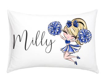 Peut inclure: Taie d'oreiller blanche avec une illustration de pom-pom girl bleue et blanche et le nom "Milly" en cursive noire.