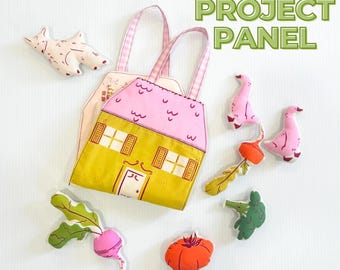 Peut inclure: Un panneau de projet Little Farm Tote comprenant un sac fourre-tout en tissu en forme de maison avec un toit rose et des murs jaunes, accompagné de découpes en tissu rembourré représentant un chat, deux oies, un radis, une betterave, un brocoli et une tomate.