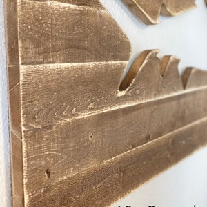 May include: Two-part distressed wood wall art featuring a wave design. The wood is a light brown colour with a distressed finish. The text "2 Part Distressed" is visible in the bottom right corner of the image.