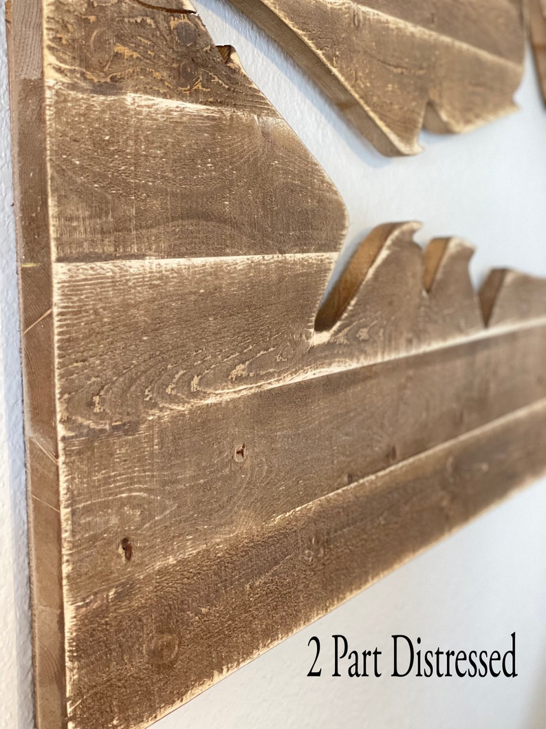 May include: Two-part distressed wood wall art featuring a wave design. The wood is a light brown colour with a distressed finish. The text "2 Part Distressed" is visible in the bottom right corner of the image.