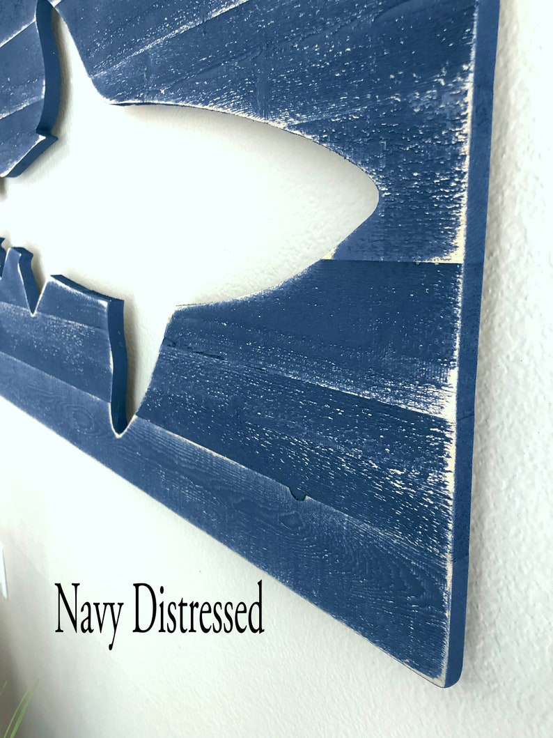 May include: A navy blue distressed wood wall art featuring a cutout of a shark. The text "Navy Distressed" is visible in the bottom left corner of the image.