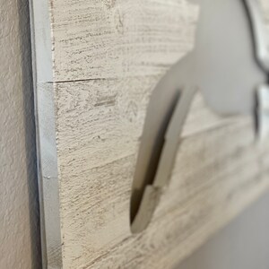 May include: White distressed wood sign with a cutout of a crab. The sign says "White Distressed" at the bottom.