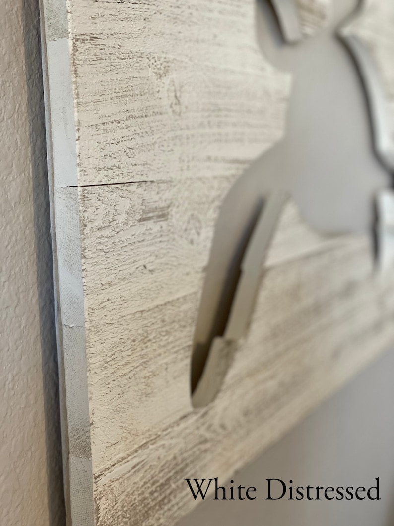 May include: White distressed wood sign with a cutout of a crab. The sign says "White Distressed" at the bottom.