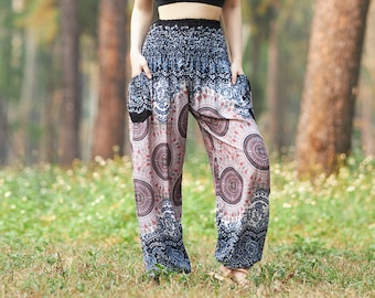 May include: A woman wearing a black crop top and patterned pants stands in a forest setting. The pants have a wide leg and a colorful, geometric print.