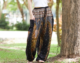 May include: A woman wearing a white tank top and black and brown patterned pants stands in a park. She is smiling and looking to the side. She is leaning against a tree.
