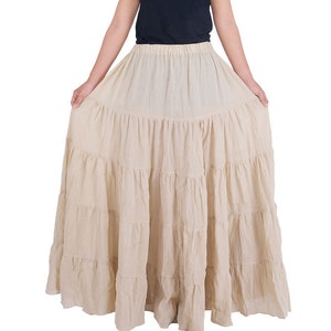May include: A beige tiered maxi skirt with a ruffled hem. The skirt is made of a lightweight fabric and has a relaxed fit.