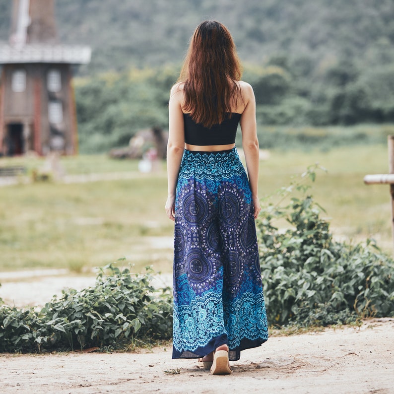 May include: A woman wearing a black crop top and a long, flowing blue and white patterned skirt. The skirt has a bohemian style with intricate designs.