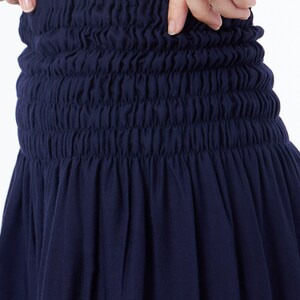 Op de afbeelding: Een donkerblauwe rok met een geplooide elastische tailleband.
