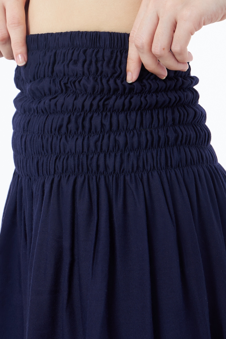 Op de afbeelding: Een donkerblauwe rok met een geplooide elastische tailleband.