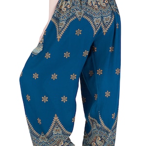 K&ouml;nnte beinhalten: Weit geschnittene Hose in Blaugr&uuml;n mit elastischem Bund, verziert mit einem sich wiederholenden Paisley-Muster in Gold und Dunkelblau an Taille und Saum, erg&auml;nzt durch ein verstreutes kleines Goldstern-Motiv auf den Beinen.
