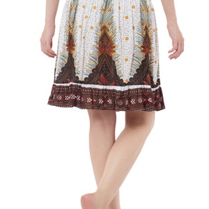K&ouml;nnte beinhalten: Ein wei&szlig;er Rock mit einem bunten Paisley-Muster und einem braunen elastischen Bund. Der Rock ist knielang und hat einen R&uuml;schen-Saum.