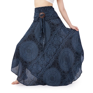 Op de afbeelding: Een enkellange rok met hoge taille in een donkerblauw en zwart kleurenpalet, voorzien van een herhalend cirkelvormig mandalapatroon en een decoratieve bruine houten ring in het midden van de elastische tailleband met hangende stoffen linten.