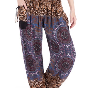 May include: Harem pants with a black elastic waistband and pockets. The pants feature a repeating pattern of blue, brown, and purple circular designs. The top portion of the pants is brown with a floral pattern.