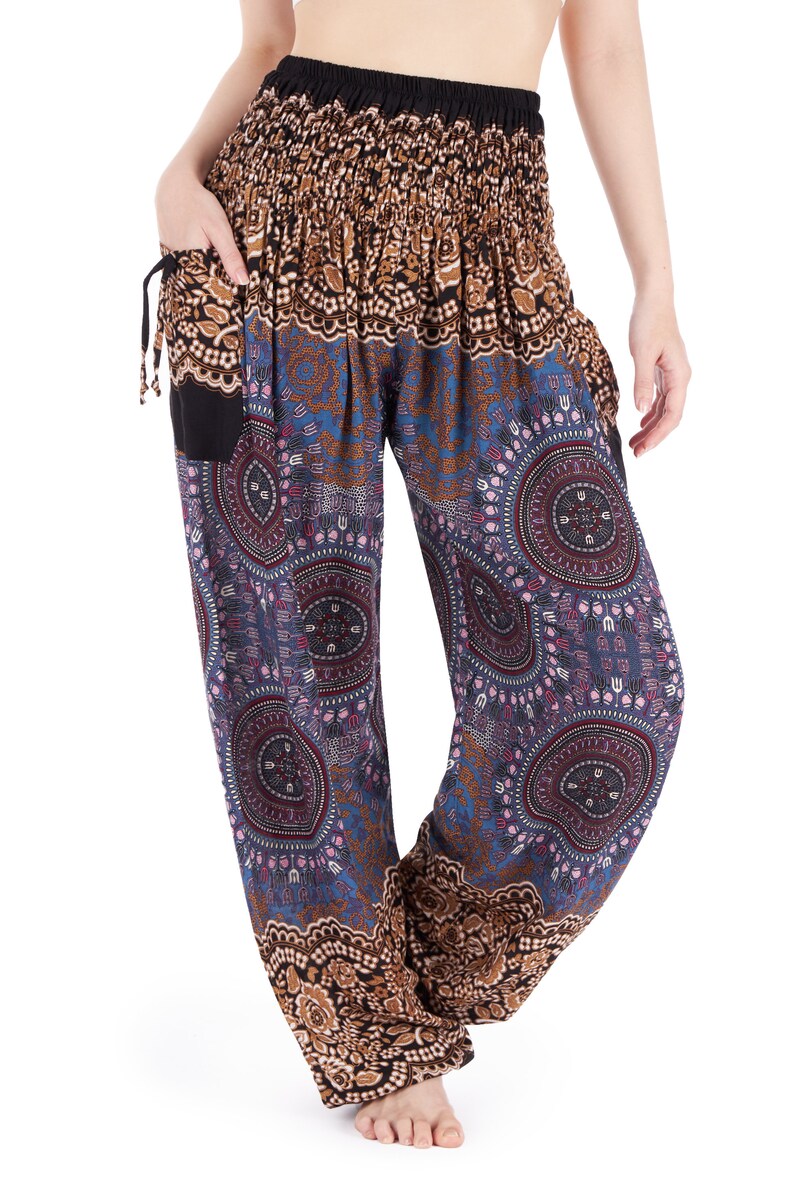 May include: Harem pants with a black elastic waistband and pockets. The pants feature a repeating pattern of blue, brown, and purple circular designs. The top portion of the pants is brown with a floral pattern.