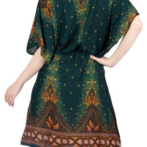 K&ouml;nnte beinhalten: Eine gr&uuml;ne, kurz&auml;rmelige Kaftan mit einem Pfauenfeder-Druck und einem Paisley-Rand. Die Kaftan hat einen G&uuml;rtel in der Taille.