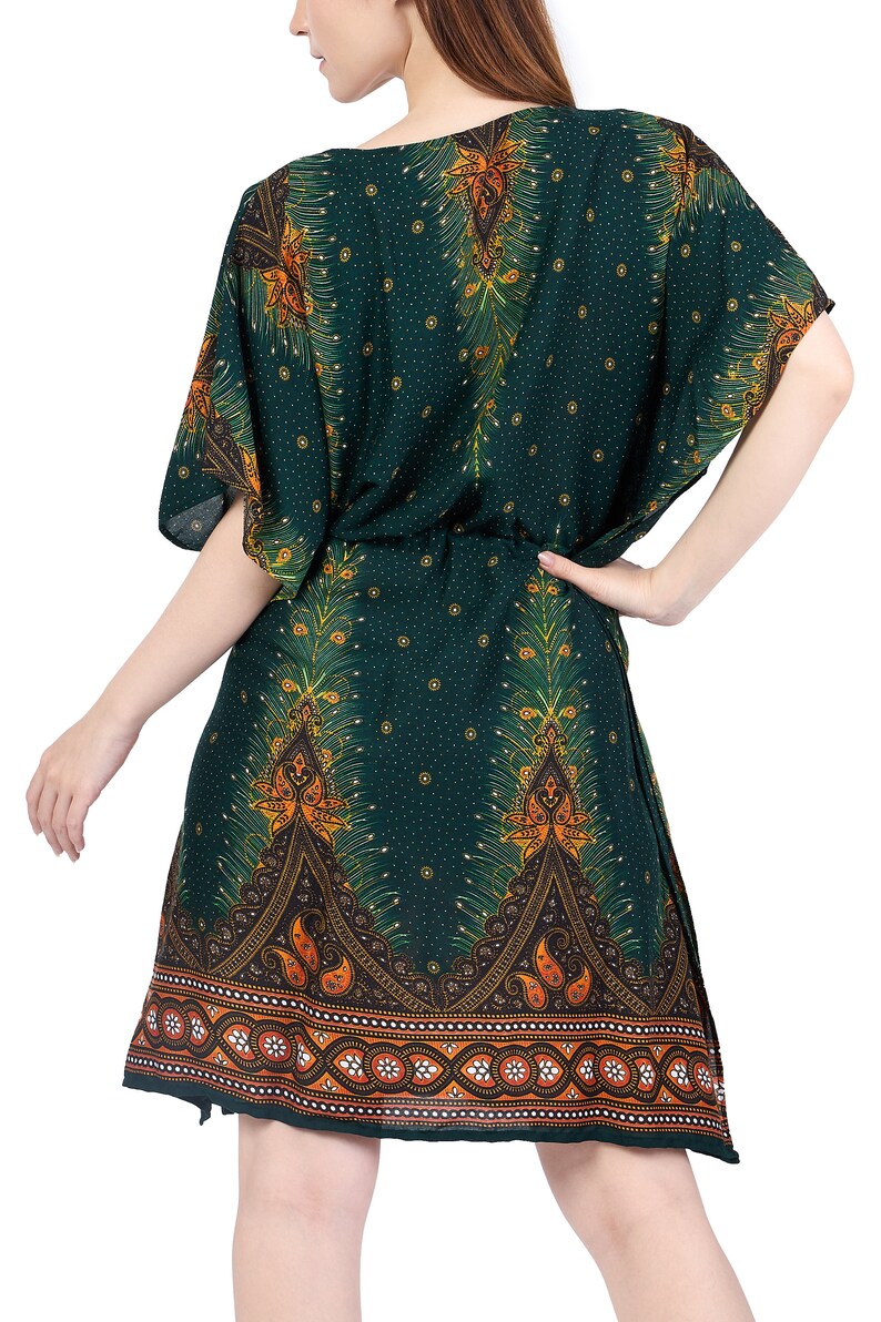 K&ouml;nnte beinhalten: Eine gr&uuml;ne, kurz&auml;rmelige Kaftan mit einem Pfauenfeder-Druck und einem Paisley-Rand. Die Kaftan hat einen G&uuml;rtel in der Taille.
