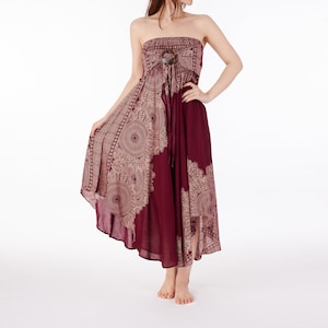 Puede incluir: Un vestido maxi sin tirantes de color burdeos con estampado de mandala dorado y blanco. El vestido tiene una cintura ajustada y un dobladillo alto-bajo.