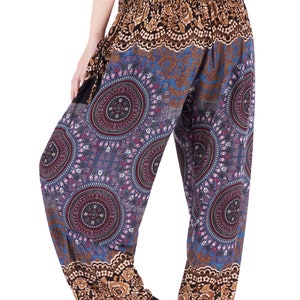 May include: Loose-fitting, patterned pants with a black elastic waistband. The pants feature a blue background with circular mandala-like designs in shades of purple, red, and pink. The cuffs and waistband have a brown floral pattern.