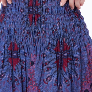 Peut inclure: Une jupe &agrave; motif bleu et rouge avec une taille &eacute;lastique. La jupe a un motif paisley avec un motif de type mandala.