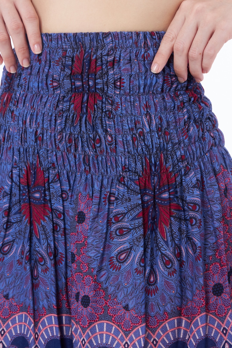 Peut inclure: Une jupe &agrave; motif bleu et rouge avec une taille &eacute;lastique. La jupe a un motif paisley avec un motif de type mandala.