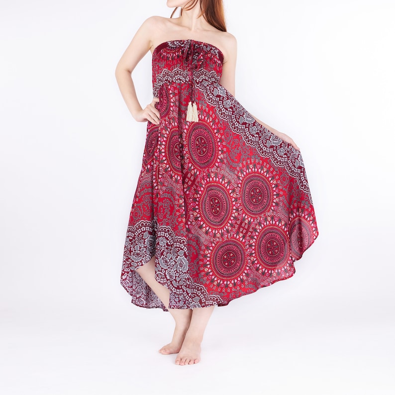 Pode incluir: Um vestido maxi vermelho sem al&ccedil;as com estampa de mandala branca e cinza. O vestido tem uma cintura franzida e um la&ccedil;o de franja.