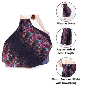 May include: A long, asymmetrical maxi skirt with a floral print in shades of pink, blue, and green on a black background. The skirt has an elastic smocked waist with a drawstring.