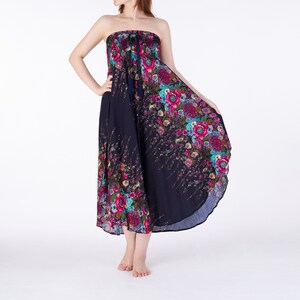 May include: A strapless maxi dress with a floral print in shades of pink, blue, and green on a navy blue background. The dress has a gathered waist and a flowing skirt.
