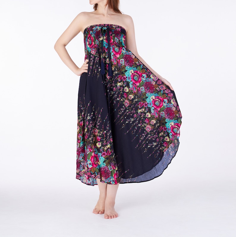 May include: A strapless maxi dress with a floral print in shades of pink, blue, and green on a navy blue background. The dress has a gathered waist and a flowing skirt.