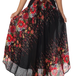 May include: A black maxi skirt with a floral print featuring red, yellow, and blue flowers. The skirt has a brown belt with a large buckle.