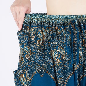 K&ouml;nnte beinhalten: Weit geschnittene Hose in tiefem Petrolblau mit einem komplizierten Paisley-Muster in Orange-, Wei&szlig;- und Dunkelblaut&ouml;nen. Die Hose verf&uuml;gt &uuml;ber einen elastischen Bund mit passendem Stoff-Kordelzug und seitlichen Eingrifftaschen.